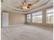 The primary bedroom features three large windows, neutral walls, and a ceiling fan at 8885 Camp Tree Ct, Winston, GA 30187