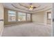 Neutral walls, a coffered ceiling and large windows highlight this cozy carpeted primary bedroom at 8885 Camp Tree Ct, Winston, GA 30187