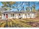 Back exterior view showcasing a single-story house with a red door and a well-maintained lawn at 147 Reynolds Bridge Rd, Kingston, GA 30145