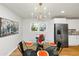 Sunlit dining area featuring a modern chandelier, glass table, and an adjacent kitchen with stainless steel appliances at 3187 Clifton Church Rd, Atlanta, GA 30316