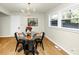 The dining area features a modern light fixture, a round glass table, and natural light from a window with backyard views at 3187 Clifton Church Rd, Atlanta, GA 30316