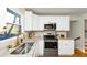 Renovated kitchen featuring stainless steel appliances, granite countertops, white cabinets, and a stylish gold faucet at 3187 Clifton Church Rd, Atlanta, GA 30316