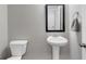 Well-lit half bathroom with a pedestal sink and decorative mirror at 557 Clinton Dr, Temple, GA 30179