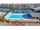 Aerial view of a bright blue community pool and nearby pickleball courts, surrounded by lush greenery at 2212 Whistler Ne Way, Lawrenceville, GA 30043