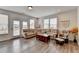 Open living room with a large sectional sofa, wood floors, a comfy chair and lots of natural light at 2212 Whistler Ne Way, Lawrenceville, GA 30043