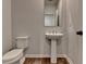 Powder room featuring hard wood floors, pedestal sink and toilet at 2212 Whistler Ne Way, Lawrenceville, GA 30043