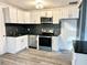 Modern kitchen featuring stainless steel appliances, white cabinets, and black countertops at 2495 Se Glendale Se Cir, Smyrna, GA 30080