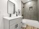 Modern bathroom with a gray vanity, a stylish mirror, and a shower-tub combination with tiled walls at 921 Cone Rd, Forest Park, GA 30297
