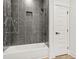 The bathroom features a new white tub with a tiled shower, and a door to the outside at 921 Cone Rd, Forest Park, GA 30297