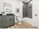 Modern bathroom boasts a granite vanity, framed mirror, and a tub with dark gray marbled tile at 921 Cone Rd, Forest Park, GA 30297