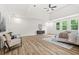 Sunlit bedroom features wood floors, a dark console, and large windows overlooking the yard at 921 Cone Rd, Forest Park, GA 30297
