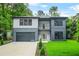 Two-story modern home with a two-tone exterior, balcony, large windows, and well-maintained landscaping at 921 Cone Rd, Forest Park, GA 30297