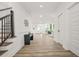 Bright foyer featuring wood-look floors, white walls, and an open floor plan leading to a living space at 921 Cone Rd, Forest Park, GA 30297