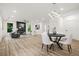 Open-concept living and dining area featuring modern lighting, a fireplace, and large windows for natural light at 921 Cone Rd, Forest Park, GA 30297
