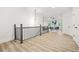 Bright living room features light wood floors and a black wrought iron railing with modern light fixture at 921 Cone Rd, Forest Park, GA 30297