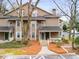 Two-story townhome with neutral siding and a cozy covered entrance, surrounded by mature trees and landscaping at 2116 N Forest Trl, Dunwoody, GA 30338