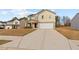 Inviting two-story house with a long driveway leading to an attached two-car garage at 310 Indian Lake Trl, Villa Rica, GA 30180