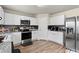 Modern kitchen showcasing stainless steel appliances, sleek cabinets, and granite countertops with a stylish tile backsplash at 310 Indian Lake Trl, Villa Rica, GA 30180