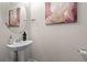 A powder room featuring a pedestal sink, and decorative mirror and artwork to complete the space at 310 Indian Lake Trl, Villa Rica, GA 30180