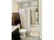 Bathroom with shower-tub combo, neutral tiling, dark wood cabinet and a curtain at 4567 Duncan Dr, Sugar Hill, GA 30518