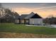 A modern home with white siding, dark accents, and a manicured lawn under a colorful sky at 1270 Sandhill Hulett Rd, Villa Rica, GA 30180