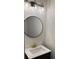 Close up of bathroom with a black vanity, round mirror, and stylish lighting at 602 Birch River Ln, Lawrenceville, GA 30043