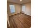Bedroom featuring two windows, hardwood floors, neutral paint, and a door, providing ample natural light at 602 Birch River Ln, Lawrenceville, GA 30043