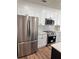 Modern kitchen featuring stainless steel refrigerator, stove and sleek white cabinets at 602 Birch River Ln, Lawrenceville, GA 30043