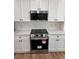 Kitchen featuring stainless steel microwave and oven with custom white cabinets at 602 Birch River Ln, Lawrenceville, GA 30043