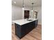 Kitchen island with stainless steel sink, black cabinets and white countertops at 602 Birch River Ln, Lawrenceville, GA 30043