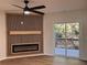 Stylish living room with fireplace, custom wood accent wall, ceiling fan, and sliding glass door to balcony at 602 Birch River Ln, Lawrenceville, GA 30043