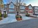 Street view of multiple brick townhomes with two-car garages and tidy landscaping along the drive at 602 Birch River Ln, Lawrenceville, GA 30043