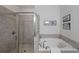 Bright bathroom featuring a glass shower, soaking tub, and neutral tile surround at 2051 Glenview Park Cir, Duluth, GA 30097