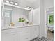 Bathroom featuring double sinks with gold hardware, a large mirror, and ensuite access at 1019 Cooks Farm Way, Woodstock, GA 30189