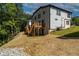 Back of home showing wood stairs and deck in yard with unfinished landscaping at 2387 Highpoint Rd, Snellville, GA 30078