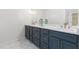 Bathroom with double vanity, marble countertop, sleek faucets, and blue cabinetry at 4051 Ridgehurst Se Dr, Smyrna, GA 30080