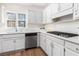 Well-lit kitchen featuring white cabinets and countertops, a stainless steel dishwasher, and a modern cooktop at 4051 Ridgehurst Se Dr, Smyrna, GA 30080