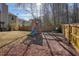 Fenced backyard with a playset including a slide and swings, ideal for Gathering enjoyment at 102 Crescent Woode Way, Dallas, GA 30157