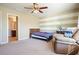 Bedroom with tan walls, a ceiling fan, a cozy armchair, and an attached bathroom at 102 Crescent Woode Way, Dallas, GA 30157