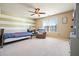 Comfortable bedroom featuring a ceiling fan, chair, and white and tan striped accent wall at 102 Crescent Woode Way, Dallas, GA 30157
