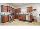 Traditional kitchen features tile floors, matching cherry wood cabinets, and stainless steel appliances at 102 Crescent Woode Way, Dallas, GA 30157