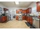 Kitchen boasts cherry wood cabinets, stainless appliances, tile floors, and lots of natural light at 102 Crescent Woode Way, Dallas, GA 30157