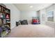 Neutral room with a bookshelf, plenty of natural light, carpet and soothing paint is ready for decor at 102 Crescent Woode Way, Dallas, GA 30157