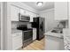 Modern kitchen with stainless steel appliances, granite countertops, and white cabinetry providing a sleek cooking space at 3110 Pine Heights Ne Dr, Atlanta, GA 30324