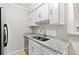 Modern kitchen featuring granite counters and stainless steel appliances, complemented by bright white cabinets and wood-style flooring at 3110 Pine Heights Ne Dr, Atlanta, GA 30324