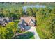 Aerial view of an estate home situated on a lush lot, with a lake view beyond the mature trees at 505 Cochran Dr, Norcross, GA 30071