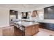 Well-lit kitchen boasting a large island, marble countertops, stainless steel appliances, and dark cabinets at 505 Cochran Dr, Norcross, GA 30071
