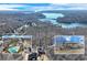 Aerial view of home showcasing lake views, private pool, and landscaped yard with wooded surroundings at 6225 Leeward Tide Ct, Cumming, GA 30041