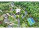 Beautiful aerial view featuring a pool, tennis court, clubhouse, and residential homes at 6225 Leeward Tide Ct, Cumming, GA 30041
