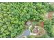 Aerial view of a home nestled in a lush, green forest, showcasing the serene and private setting at 6225 Leeward Tide Ct, Cumming, GA 30041